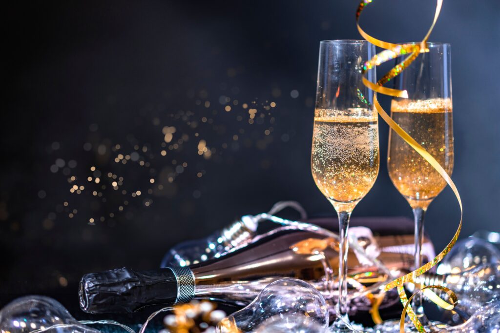 Two champagne glasses with a bottle and festive decorations, perfect for celebrations.